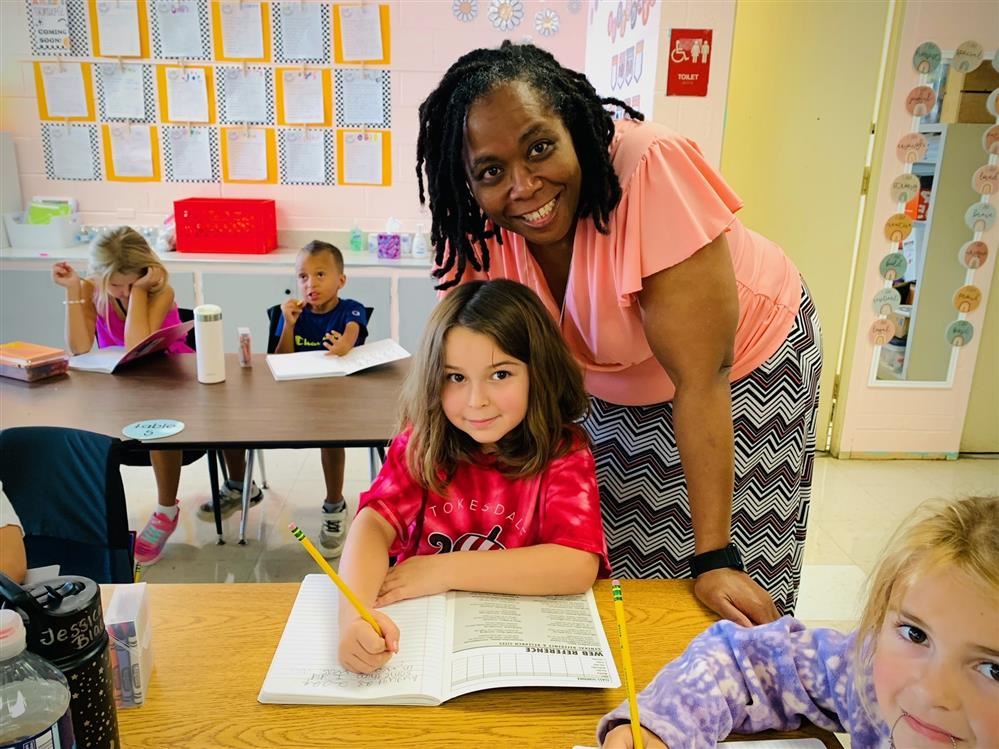 Mrs. Donaldson smiles with student.  